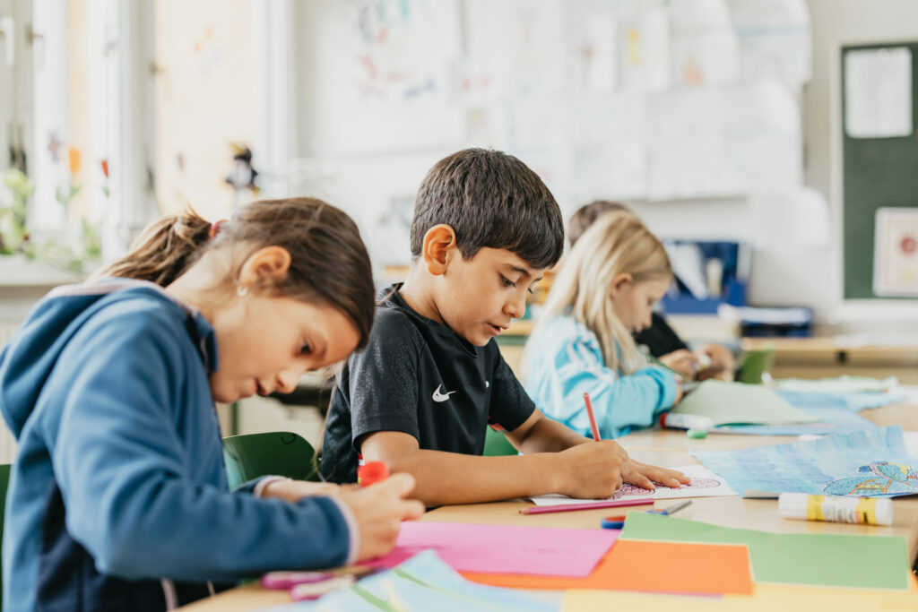 Kinder in einer Grundschule basteln und malen